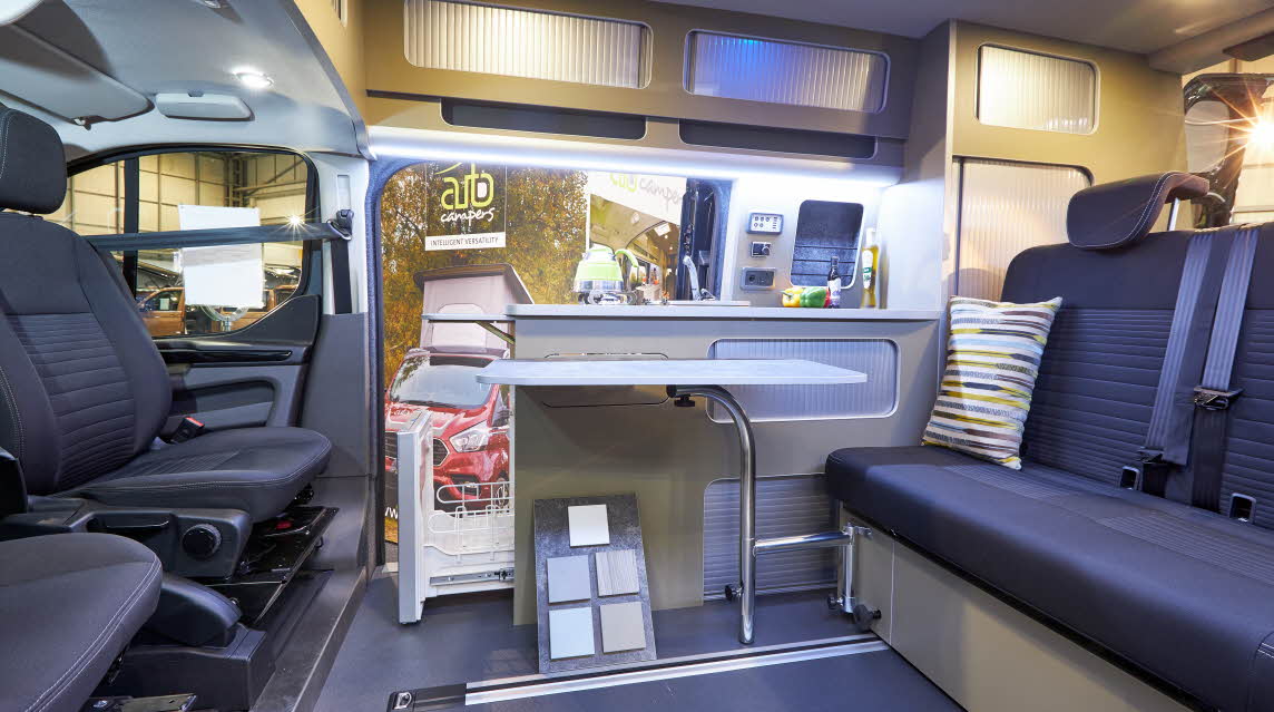 Campervan, blue upholstery, stripy cushion, wooden units