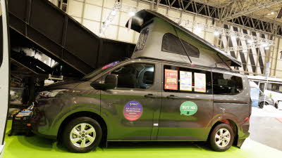 The AURA 4 Trend is metallic grey and has its rising roof fully open.  All doors are closed.