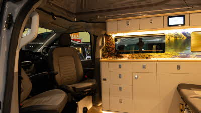 The Knights Prestige Tourer has dark brown and cream upholstery with cream cabinets.  Its rising roof is open.