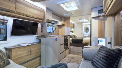 Bailey Alicanto Grande Deluxe Alvor’s interior has grey upholstery and has an L shaped soft at the front.  There is a fixed island bed in the middle of the caravan with a rear washroom.