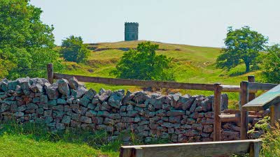 Solomon's Temple is seen over the brow of a hill, from a drystone wall