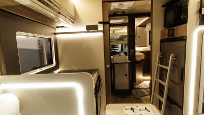 The Roller Team Pegaso 740 has cream and bronze cabinets with wooden door surrounds.  The washroom is centrally placed with a bedroom at the rear.