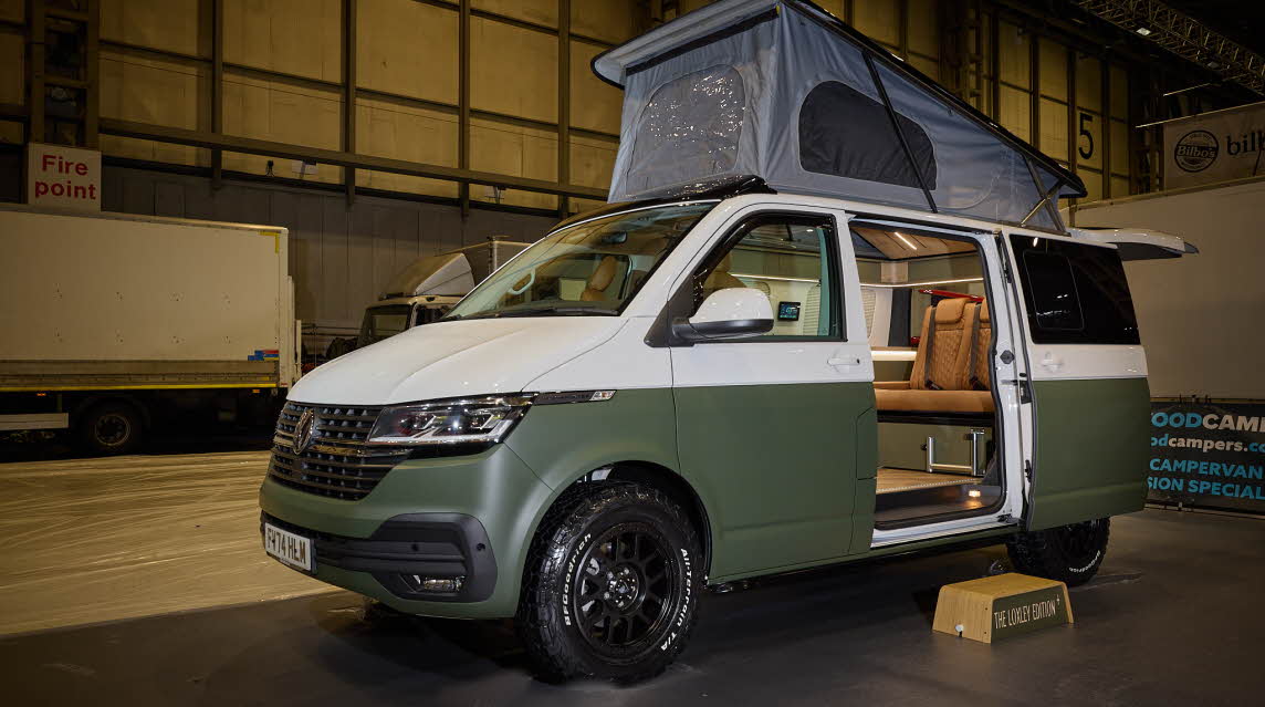 Sherwood Campers Ltd Loxley Edition Conversion SWB has a two tone exterior, white and dark green. There's a step by the open sliding door. The rising roof is fully extended.