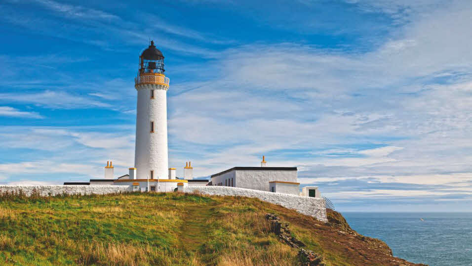 White lighthouse at Mull of Galloway overlooking calm summer seas