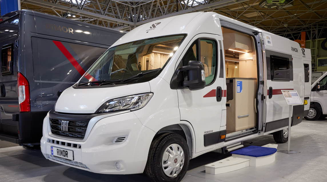 Rimor Horus 66 has a white exterior with red graphics.  The sliding door is open showing the interior, with a step to gain easy access.