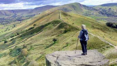 Lady standing on a rocky ledge looking out across the Peak District - member photo by Kenneth Davies
