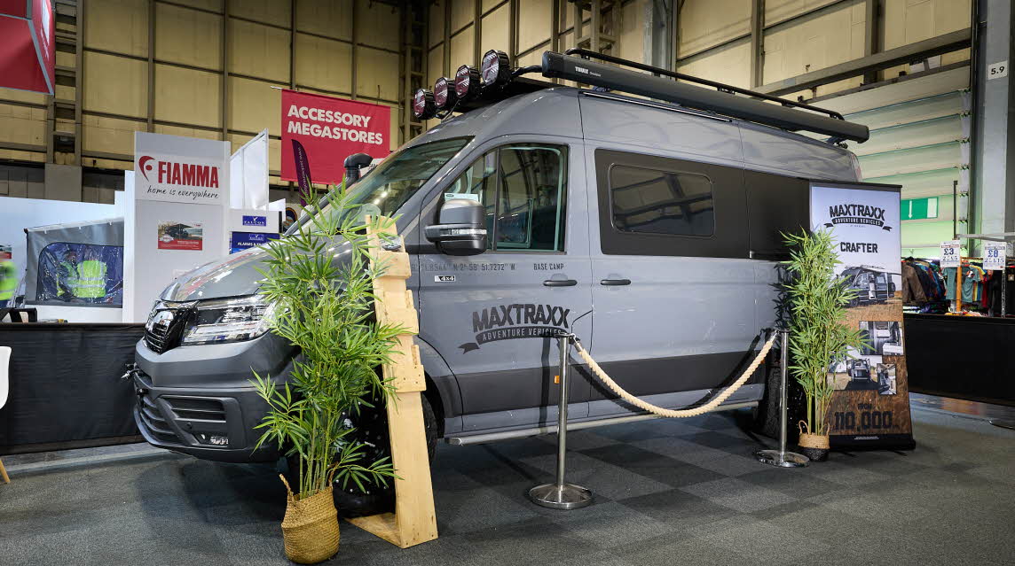 Vanworx MaxTraxx Crafter’s exterior is grey with black decals.  On the roof there is a folded awning and there are spot lights above the cab.  There are two palm trees either side of a roped off area.