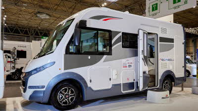 Roller Team Pegaso 590 has a white exterior and grey/red decals. The habitation door is open showing the interior with a step to gain easy access. The wheels are black alloys.  