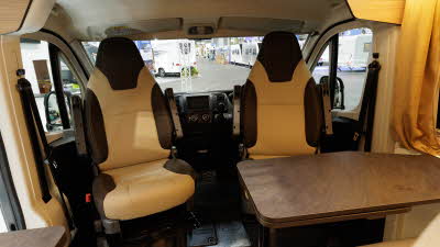 The Rimor Horus 95 has cream and brown upholstery.  The two front seats are facing into the van and there is a brown table in front of them which can be extended.