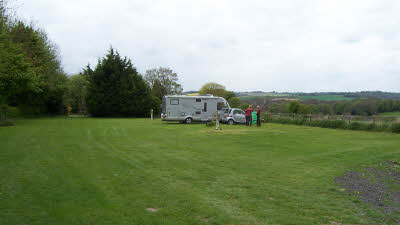 Open field with lone motorhome and car