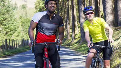 Man and woman cycling with helmets