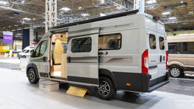 The Vantage NEO is white with black decals.  Its sliding door is open and there is step to gain easy access.