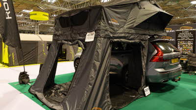 The RoofBunk Explorer Super XL has green canvas.  Its annex has three doors which are open.  It is displayed on a grey car.