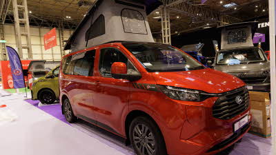 The Bespoke Leisure Bespoke Explore PHEV is red, its rising roof is open but its sliding door is closed.