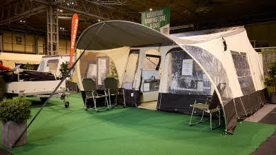 The Jametic Outdoor AS has a coffee and cream coloured canvas.  The door is open revealing the interior.  The folded unit, in cream, is to the left.