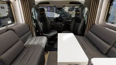 The Swift Trekker 584 has grey upholstery with the front two swivelled seats having black seats.  There's a white table which is shown folded but can be extendable.