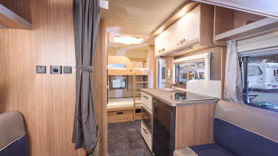 Weinsberg CaraOne 400 LK Bunks' interior is wooden with two tone sets in brown and blue.  The bunks are at the rear and there is a ladder for access to the top bunk.