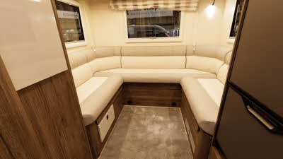 The Roller Team T-Line 700 has a cream/beige u shaped sofa with wooden panelling.  There are three windows with a striped Roman blind at the rear.