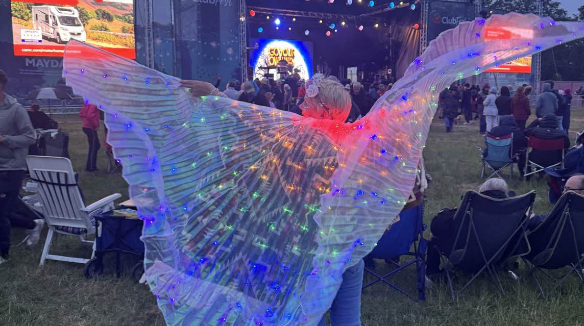 a ClubFest-goer shows off her light-up wings floating out behind her