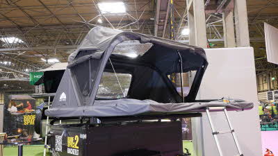 The Roof Space 2 is fully extended on a trailer. The canvas is pale grey. There is a platform with a sturdy ladder to gain easy access.