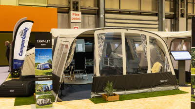 The Camp-Let North has cream and brown canvas.  There are patterned curtains on all windows.  There are chairs dotted around inside the tent and the bedroom doors are open.