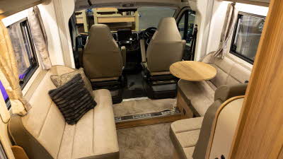 The Bailey Autograph 81-5 has two tone brown upholstery with wooden furniture.  There is a cocktail by one of the sofas in the front lounge.  It has two large windows.