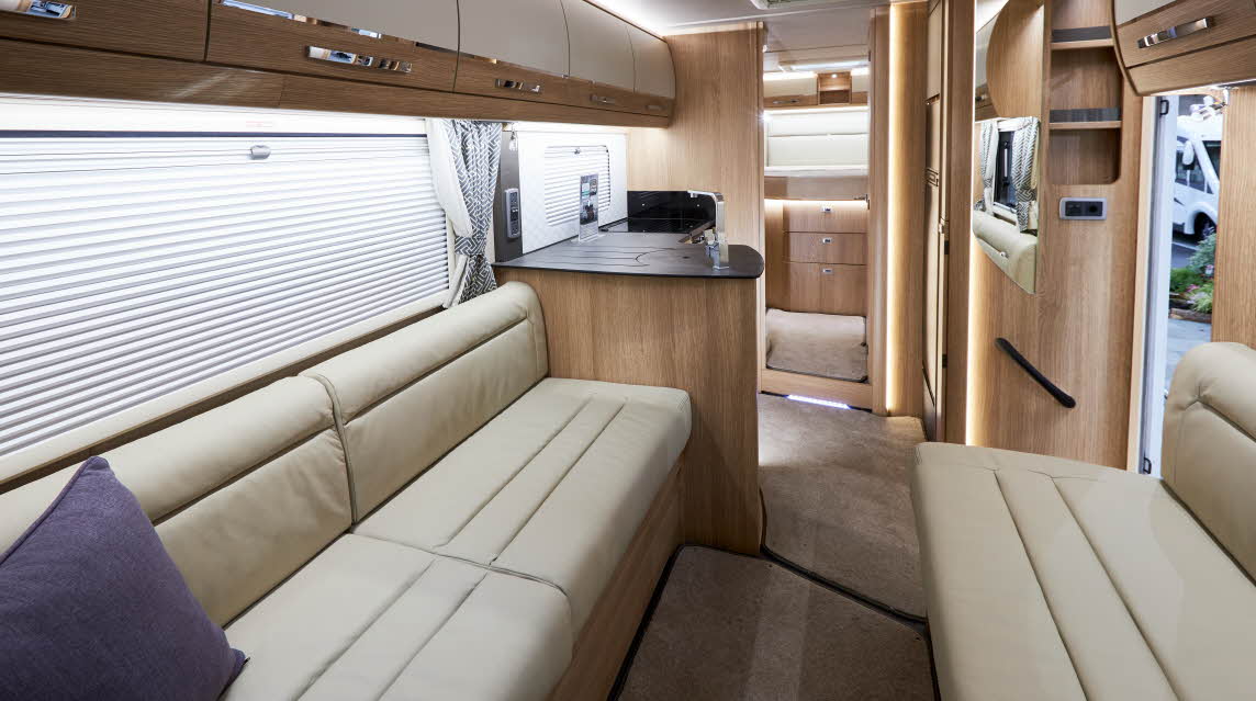 Interior, cream sofas, wood cupboards, purple cushion