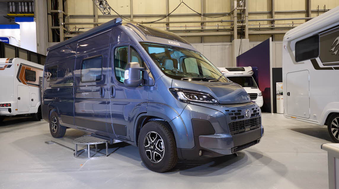 The Knaus Boxlife 600 ME Platinum Selection is blue.  There is a metal step beside the closed sliding door.