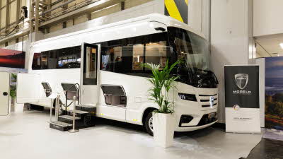 The MORELO PALACE 90M is black and white.  There are steps leading to the interior.  Its habitation and all its locker doors are open.