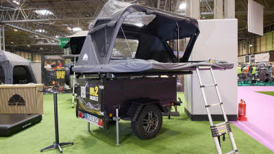 The Roof Space 2 is fully extended on a trailer. The canvas is pale grey. There is a platform with a sturdy ladder to gain easy access.