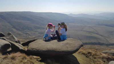 Two children enjoy the views from the top of Kinder Scout in the Peak District National Park