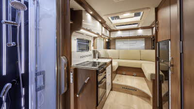 Frankia F-Line I 680 PLUS has cream leather upholstery, white wooden overhead lockers.  The kitchen work surface is white with a hob and separate sink.  The furniture is wooden.  There are three roof lights.  The separate shower is white and black.