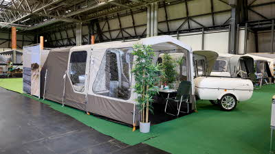 Campmaster 600LX exterior, cream/brown canvas, large entrance door, potted plant