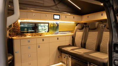 The Knights Prestige Tourer has dark brown and cream upholstery with cream cabinets.  Its rising roof is open.