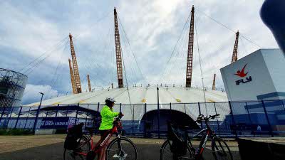 Two electric bikes stopped in front of the O2 London in Greenwich