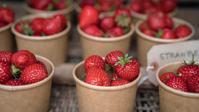 A close up image of strawberry tubs being sold at a Farmers Market in Cornwall, UK