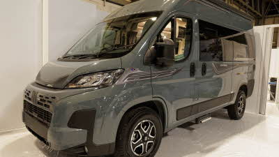 The Auto-Sleeper Symbol has a grey exterior with black decals.  Its sliding door is closed and its step below it is retracted.