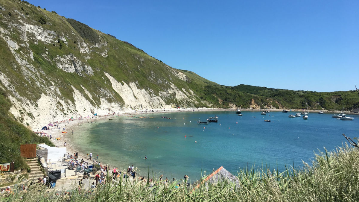 Rocky cliff faces overlooking blue waters of Lulworth Cove