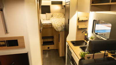 The Pilote Atlas A690GJ has two rear fixed single beds, the kitchen is to the left.  The furniture is wooden and there are two steps to gain access to the beds. 