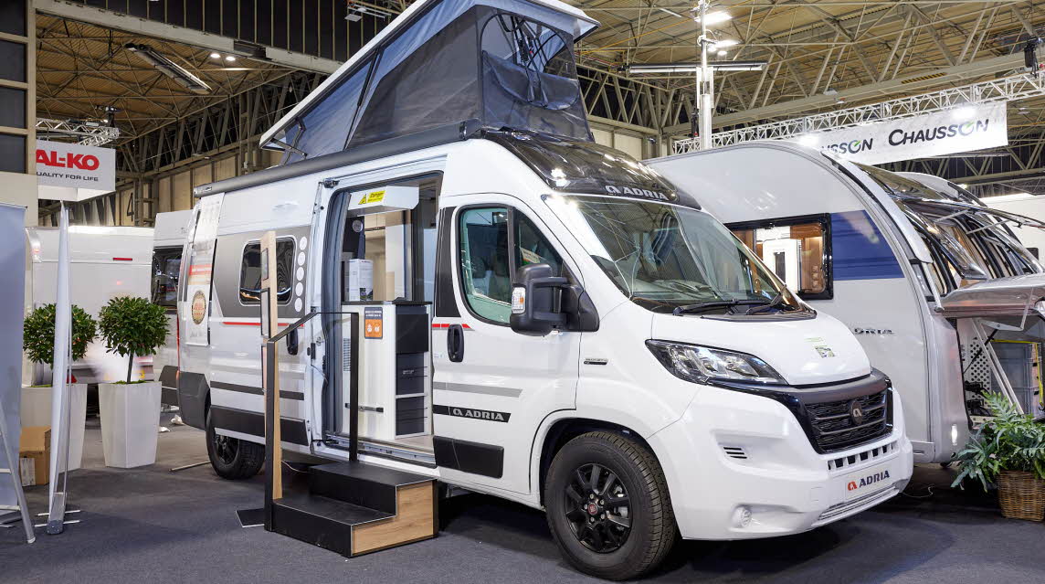 Adria Twin Sports 600 SPB exterior, van conversion is white, the sliding door is open showing into the interior, with a double step to gain easy access.  The rising roof is fully open with blue canvas.
