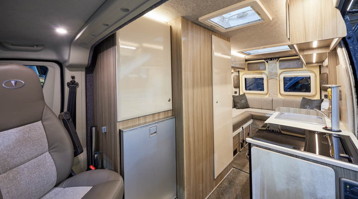 Vantage SOL has two tone beige and brown upholstery; the panelling is wood.  The overhead lockers are cream.  There is a rear lounge.