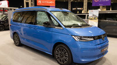 The Hillside Leisure MVX is blue, its rising roof and sliding doors are closed.