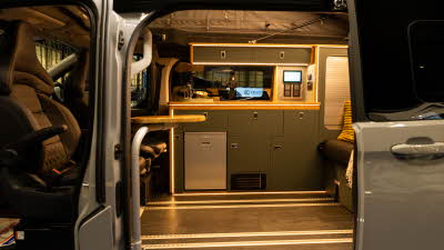 The Landseer Custom 2.0 has black upholstery with dark grey cabinets and a silver fridge. 