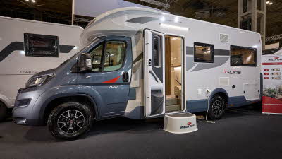 Roller Team T-Line 700’s exterior is has a blue cab with a white body.  It has two tone grey decals.  The habitation door is open and there is a large white step to gain easy access.
