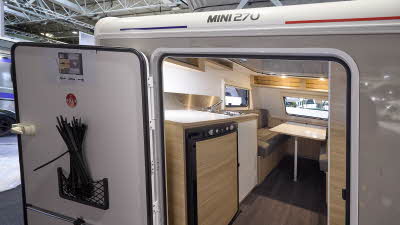 Trigano Mini Freestyle 270's interior is wooden with the kitchen to the left and the seating area to the front