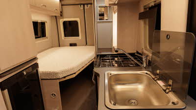 The Auto-Sleeper Active KB635 has a fixed rear French bed, the sink and hob are on the right.