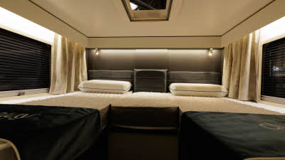The Ace Motorhomes 1500 SL has two rear elevated fixed single beds with a window either side.  There is a skylight above the beds which is open.