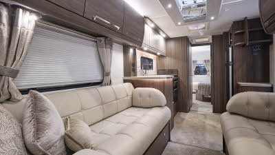 Buccaneer Commodore interior, it is cream with dark wood furniture.  There is a full sized oven in the kitchen unit.  The fixed bed is just beyond this and there are large skylights.  