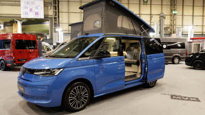 The Hillside Leisure MVX is blue, its rising roof and sliding door are open.