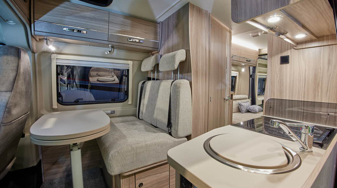 Van conversion interior, cream upholstery, wooden furniture